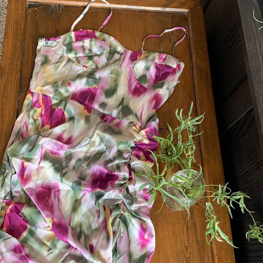 Silky ruched dress with slit in vibrant green and fuchsia tones.